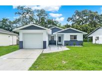 Charming single-story home featuring a well-manicured lawn and a modern two-tone color scheme at 324 James Pl, St Cloud, FL 34769