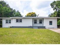 Charming single-story home featuring a freshly painted exterior, manicured lawn, and classic landscaping at 3410 Calumet Dr, Orlando, FL 32810