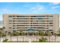 Elegant condo building with manicured landscaping and palm trees, offering a luxurious beachfront living experience at 4621 S Atlantic Ave # 7202, Port Orange, FL 32127