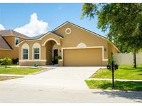 Charming single-Gathering home featuring a well-maintained lawn, two-car garage, and welcoming front entrance at 608 Washington Way, Haines City, FL 33844