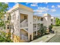 Beautiful condo building featuring balconies and a well-maintained facade with stucco and painted trim details at 7509 Mourning Dove Cir # 302, Reunion, FL 34747