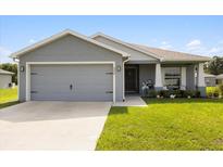 Charming single-story home featuring a gray exterior, well-manicured lawn, and a two-car garage at 9020 Se 42Nd Ct, Ocala, FL 34480