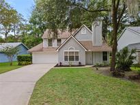Charming two-story home with a well-manicured lawn, attached garage, and mature trees at 938 Southridge Trl, Altamonte Springs, FL 32714