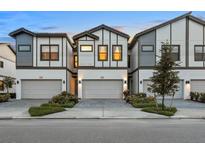 Modern townhomes featuring two-car garages, sleek design, and inviting curb appeal with manicured landscaping at 10293 Ebb Tide Ln, Orlando, FL 32821