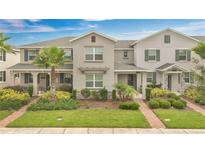 Charming townhome boasts a well-manicured lawn, lovely landscaping, and inviting facade at 12015 Prologue Ave, Orlando, FL 32832