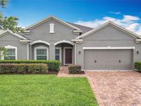 Charming single-story home featuring a well-manicured lawn and a brick-paved driveway at 1540 Orange Valley Rdg, Ocoee, FL 34761