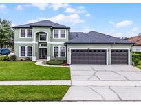 Charming two-story home featuring a three-car garage and well-manicured lawn at 201 Hammock Dunes Pl, Orlando, FL 32828
