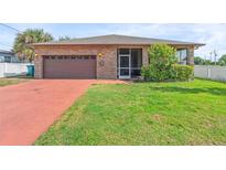 Single-story home with a brick facade, attached garage, screened entry, and well-maintained lawn at 2017 W Gore St, Orlando, FL 32805