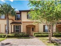 Charming two-story townhome featuring lush landscaping and a welcoming entryway at 223 Palermo St, Davenport, FL 33897