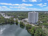 Stunning aerial view of a high-rise building near a serene lake and lush greenery, offering a picturesque cityscape at 400 E Colonial Dr # 1103, Orlando, FL 32803