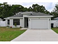 Charming single-story home with a gray exterior, well-manicured lawn, and a two-car garage at 508 Bennett St, Auburndale, FL 33823