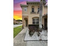 Inviting two-story townhome with well-maintained landscaping and charming architectural details at 5515 Paradise Cay Cir, Kissimmee, FL 34746