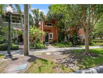 Two-story home with terracotta-colored exterior, lush landscaping, and a welcoming front walkway at 602 E Livingston St # 3, Orlando, FL 32803