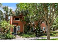 Charming two-story home with a terracotta facade, lush landscaping, and unique arched windows at 602 E Livingston St # 3, Orlando, FL 32803