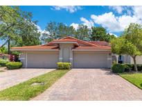 Beautiful villa with a red tile roof, two-car garage, and a brick paver driveway at 8035 Bayside View Dr, Orlando, FL 32819