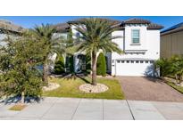 Beautiful two-story home featuring a brick driveway, manicured lawn, and a two-car garage at 8085 Ludington Cir, Orlando, FL 32836