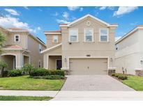 Inviting two-story home featuring a neutral color scheme, attached two car garage, and well maintained lawn at 8975 Fluffy Lie Ct, Davenport, FL 33896