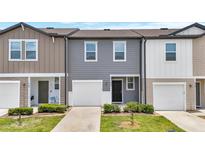 Charming townhome featuring a one-car garage, well-maintained lawn, and a welcoming front entrance at 912 Grandin St, Davenport, FL 33837