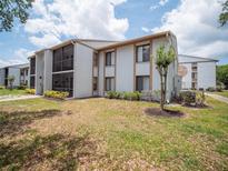 Well-maintained condo complex with two-story units, manicured landscaping, and a screened-in patio at 952 Courtyard Ln # 41, Orlando, FL 32825