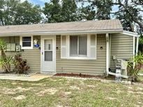 Charming single-story home featuring light green siding, a welcoming front door, and well-maintained landscaping at 10301 Us Highway 27 # 34, Clermont, FL 34711