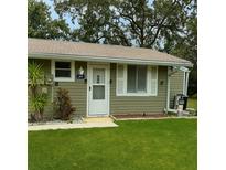 Charming single-story home featuring light green siding, a well-manicured lawn, and a welcoming front entrance at 10301 Us Highway 27 # 34, Clermont, FL 34711