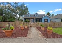 Charming blue two-story home with a picket fence and beautifully landscaped front yard at 1407 S Palmetto Ave, Sanford, FL 32771