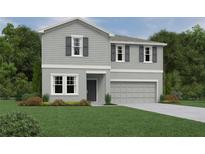 Charming two-story home with light gray siding, dark shutters, manicured lawn, and a two-car garage at 1646 Cane Bamboo Drive, St Cloud, FL 34771
