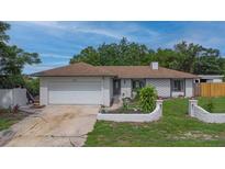 Charming single-story home featuring a well-manicured lawn, attached garage, and inviting curb appeal at 2112 Plymouth Sorrento Rd, Apopka, FL 32712