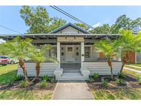 Charming home featuring mature palm trees, a covered porch, and fresh exterior paint at 314 E Harwood St, Orlando, FL 32801