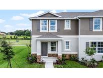 Charming two-story townhome featuring a covered entry and stone accents, creating an inviting curb appeal at 6006 Galloping Dr, Apopka, FL 32712
