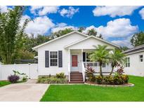 Charming single-story home with a well-manicured lawn, complemented by a small front porch and landscaped garden beds at 824 Timor Ave, Orlando, FL 32804