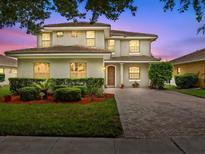 Charming two-story home with a well-manicured lawn and a paved driveway at 9034 Paolos Place Paolos Place, Kissimmee, FL 34747