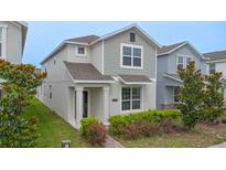 Charming two-story home featuring manicured landscaping, a welcoming entryway, and neutral color palette at 9941 Introduction Way, Orlando, FL 32832