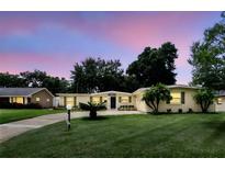 Charming single-story home with a well-manicured lawn, mature trees, and a paved driveway at 1000 Kewannee Trl, Maitland, FL 32751