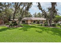 Charming single-story home with a lush green lawn and mature trees at 1425 Mt Laurel Dr, Winter Springs, FL 32708