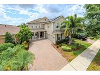 Beautiful two-story home with a well-manicured lawn, lush landscaping, and a welcoming front porch at 14744 Spotted Sandpiper Blvd, Winter Garden, FL 34787