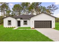 Charming single-story home featuring a well-manicured lawn and a two-car garage at 17465 Sw 41St Cir, Ocala, FL 34473