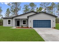 Charming single-story home with a blue garage door and freshly manicured front lawn at 17501 Sw 41St Cir, Ocala, FL 34473