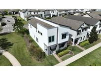Modern two-story home featuring a manicured lawn and stylish architectural design at 2035 White Feather Loop, Oakland, FL 34787