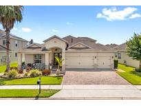 Charming single-Gathering home with a two-car garage, well-manicured lawn, and beautiful landscaping at 2051 Sandy Garden Ln, Winter Garden, FL 34787