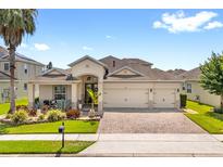 Charming single-story home with a three-car garage and well-manicured landscaping and a brick paved driveway at 2051 Sandy Garden Ln, Winter Garden, FL 34787