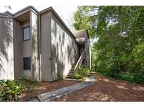 Inviting townhome featuring wood siding, stairs to the entrance and well-maintained landscaping at 211 Crown Oaks Way # 205, Longwood, FL 32779