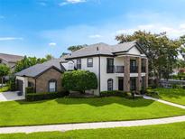 Stunning two-story home with manicured lawn, brick accents, and a charming balcony overlooking the front yard at 213 N Monterey Isle, Longwood, FL 32779