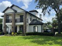 Elegant two-story home with brick accents, a second-floor balcony, lush landscaping, and a manicured lawn at 213 N Monterey Isle, Longwood, FL 32779