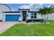 Charming single-story home with a blue garage door, stone accents, and beautifully landscaped front yard at 2390 Standing Rock Cir, Oakland, FL 34787