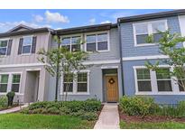 Charming two-story townhome with a welcoming yellow door and well-maintained landscaping at 3028 Water Sprite St, Orlando, FL 32808