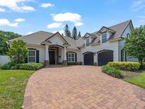 Charming two-story home features a paver driveway, three-car garage and manicured landscaping at 3535 Lake Sarah Dr, Orlando, FL 32804