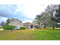 Charming single-story home with a well-manicured lawn, mature trees, and tasteful landscaping at 36730 Oconee Ave, Eustis, FL 32736