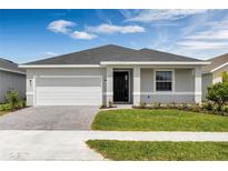 Inviting single-story home with manicured lawn, a paved driveway, and a 2-car garage at 3756 Watercliff Cir, Grand Island, FL 32735