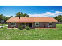 Charming single-story brick home with a well-maintained lawn and metal roof at 4160 Packard Avenue, St Cloud, FL 34772
